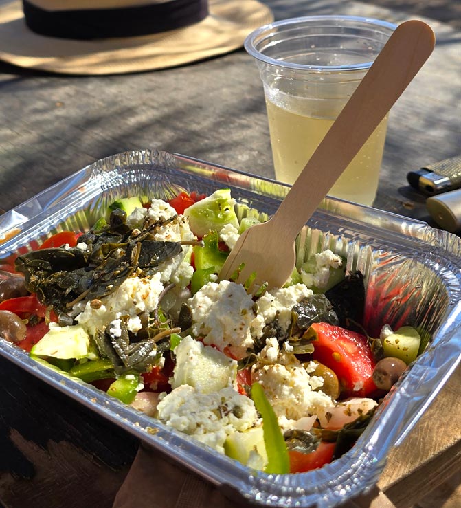 Salade grecque à la feta, tomates et câpres servie en barquette à la cantine de plage de Kalotaritissa, Amorgos