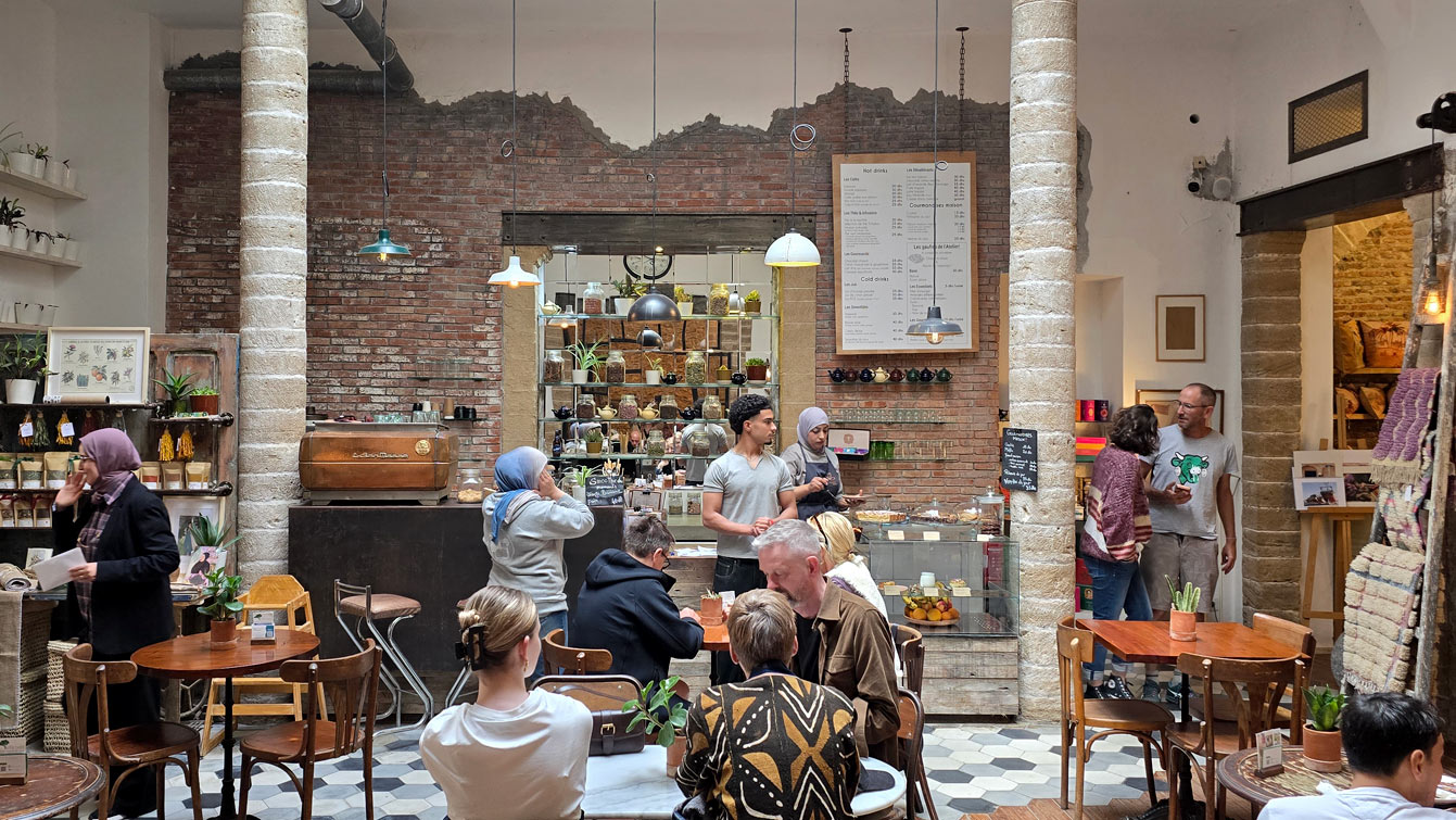 Salle café de l'Atelier Café Boutique et son étagère d'objets déco, Essaouira