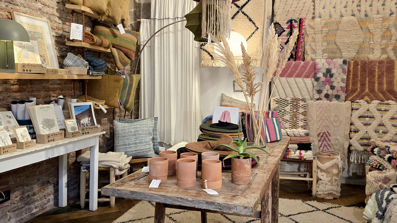 Coin déco de l'Atelier Café Boutique : tapis berbères, foutas, coussins et poteries en terre cuite, Essaouira