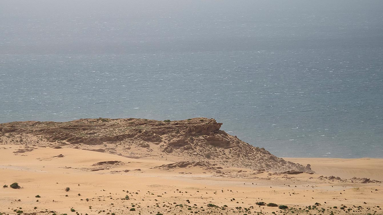 Paysage de dunes et de roche descendant vers l'océan pendant la balade en quad à Timlalin