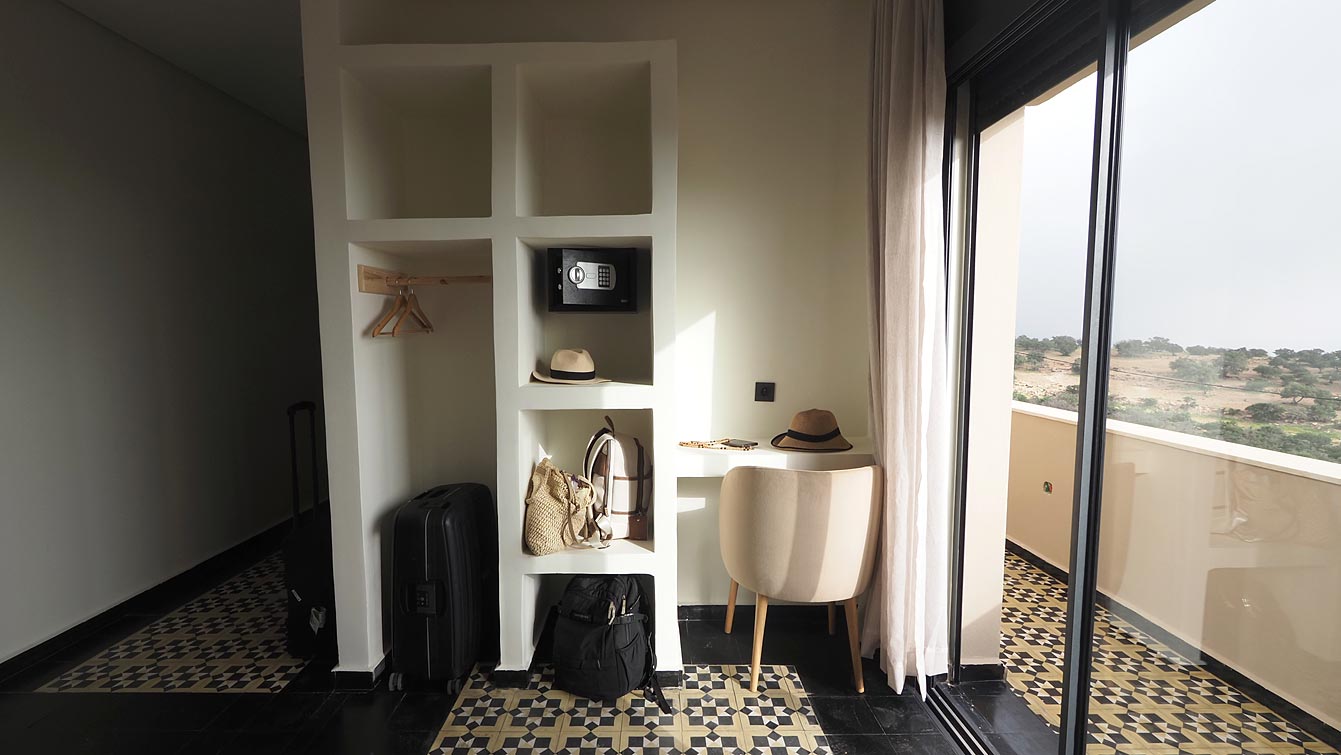 Chambre double avec lit en bois sculpté et tapis berbère à Taghazout