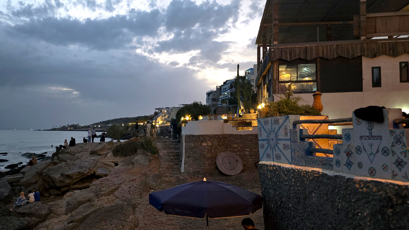 La rue qui longe la côte, bordée de terrasses et de restos