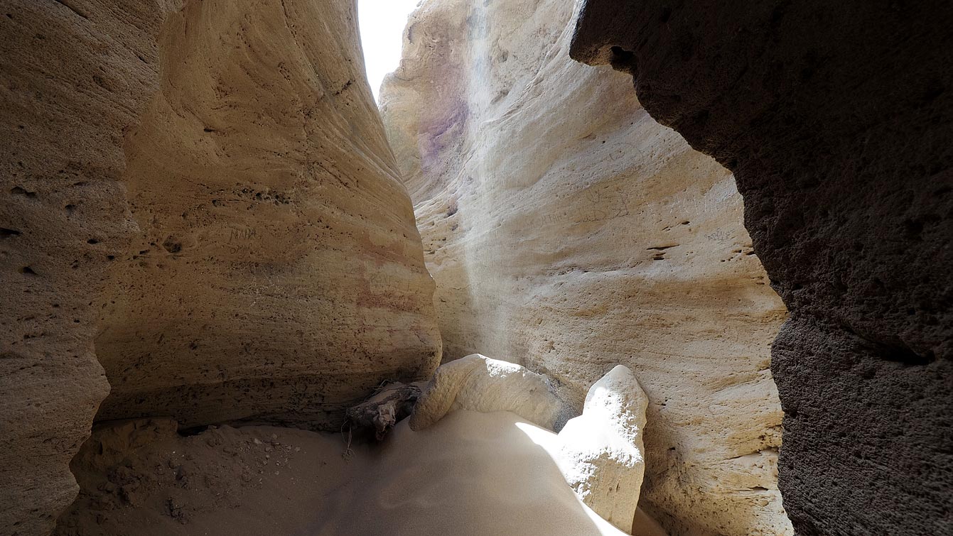 Langue de sable entre les hautes parois du canyon de Timlalin, ciel en ouverture.