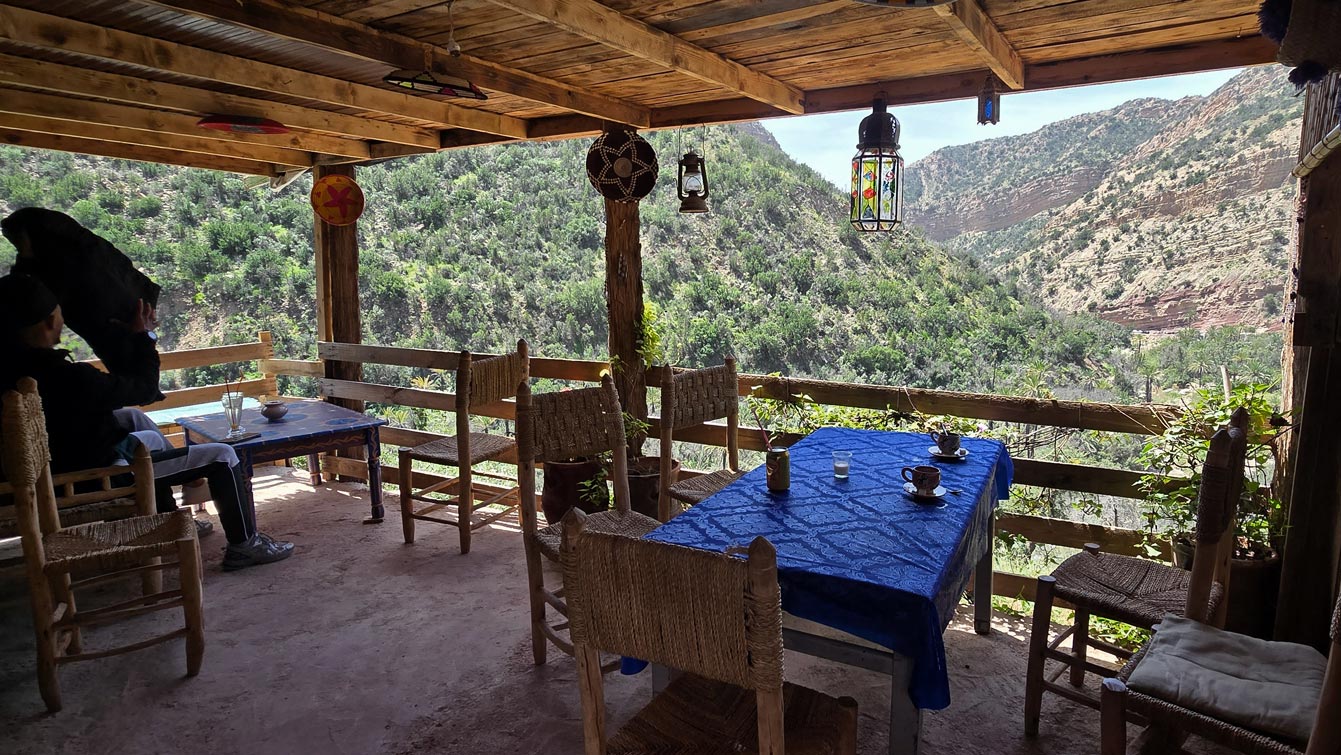 Terrasse en bois du café situé en haut des marches, lanternes et vue sur la vallée