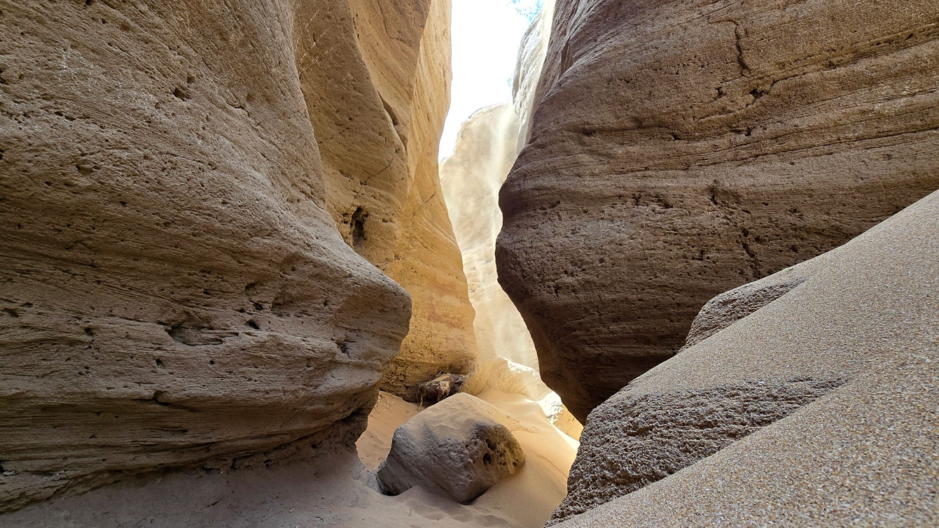 Entrée du canyon de Timlalin avec du sable s'écoulant le long des parois rocheuses.