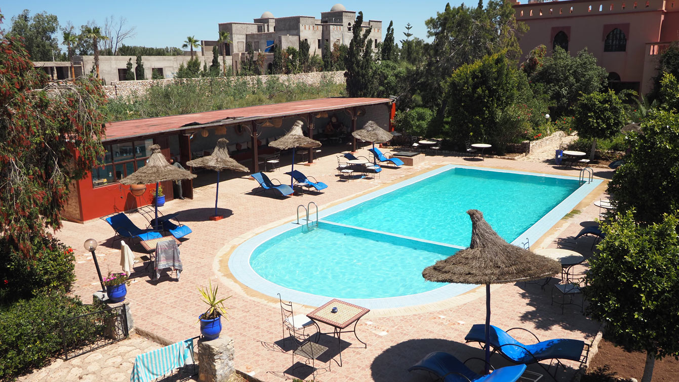 Piscine extérieure du Riad Les Deux Mondes à Essaouira avec transats et parasols en paille