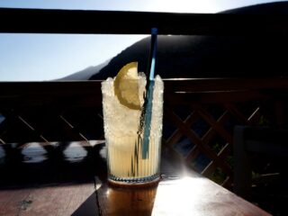 Cocktail rafraîchissant avec tranche de citron face à la mer au bar Mouros, Amorgos